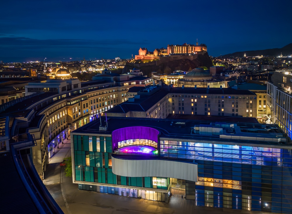 Exterior aerial shot of a hotel and spa lit up at night