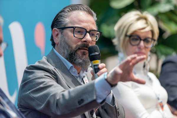 man speaking on stage at the wellness hospitality conference