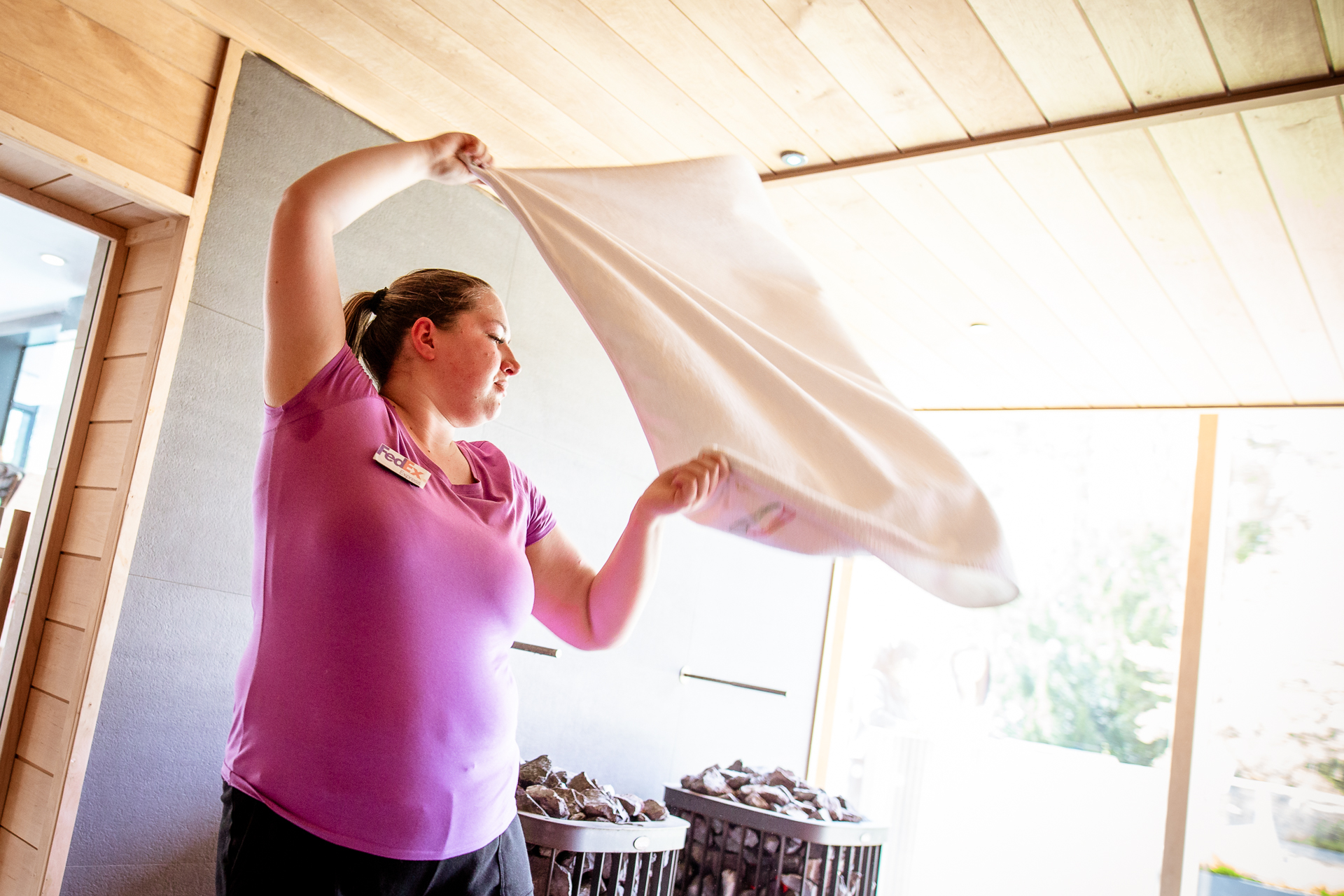 woman in pink teeshirt performs sauna ceremony