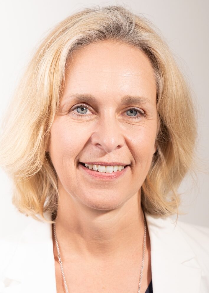 Blonde smiling woman in white jacket
