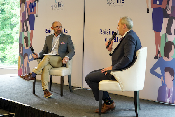 men speaking on stage at a at conference