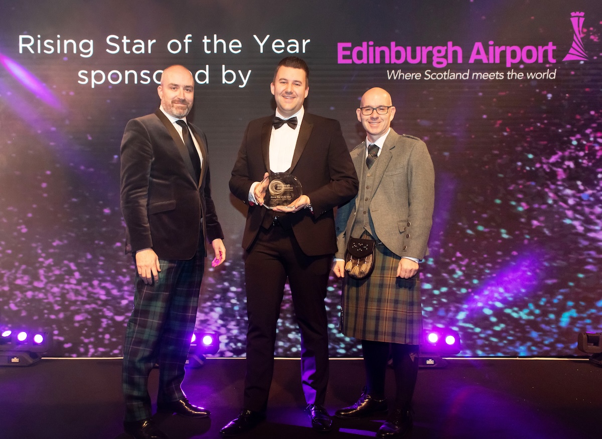 Three men at an awards ceremony