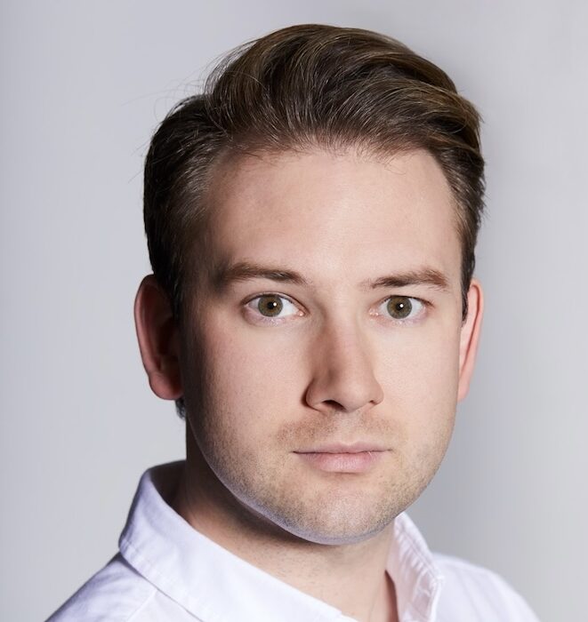 Man in white shirt looking into camera