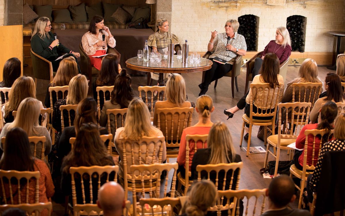 people seated, speaking at a conference