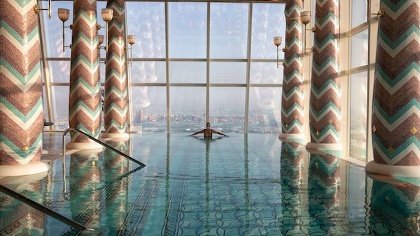 woman in a rooftop swimming pool looking at the horizon