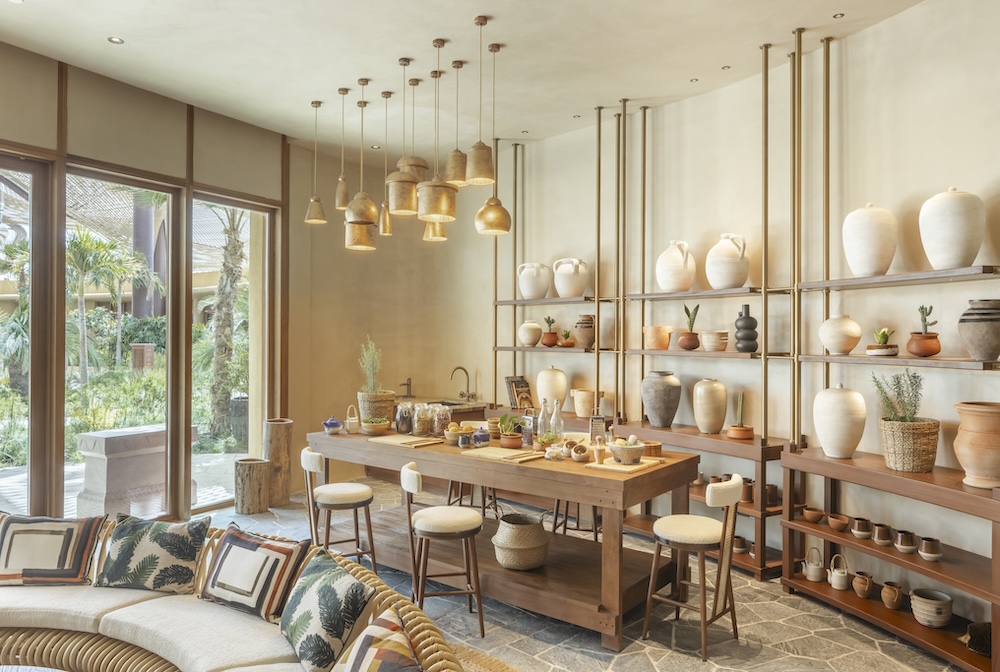 A room with a sofa, table and ceramic pots