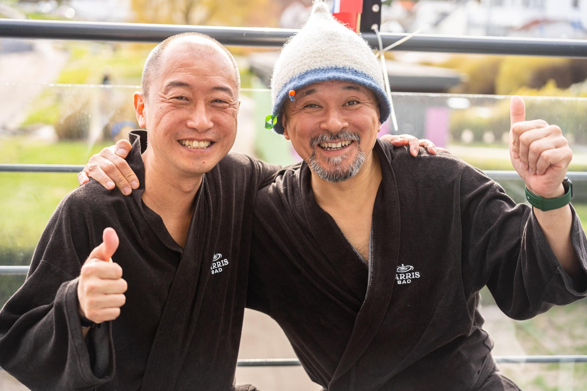 two men enjoy sauna ceremonies one is wearing a sauna hat